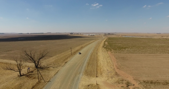 Car drives up a farm road