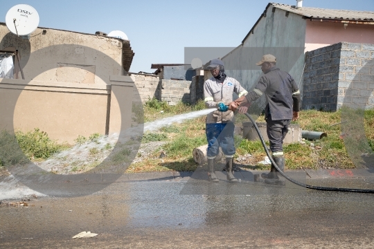 Cleaning the road using a hosepipe