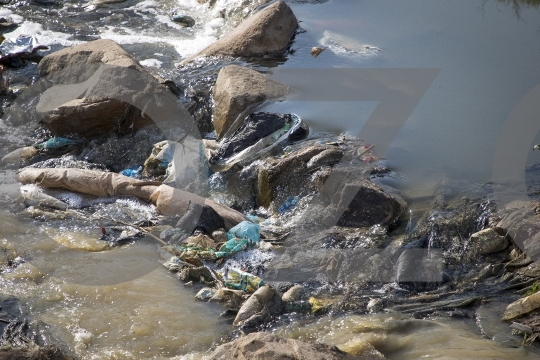 Waste and plastics in dirty water